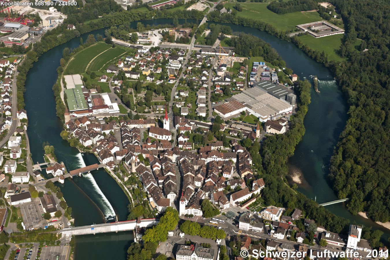 Bremgarten (AG), verkehrsberuhigte Altstadt, ein Kulturdenkmal nationaler Bedeutung. Z.T. erhaltene Stadtmauer mit Wehrgang: Spittelturm (unten Bildmitte). Gedeckte Holzbrücke; Eisenbahnbrücke der Bremgarten-Dietikon-Bahn (BDB).